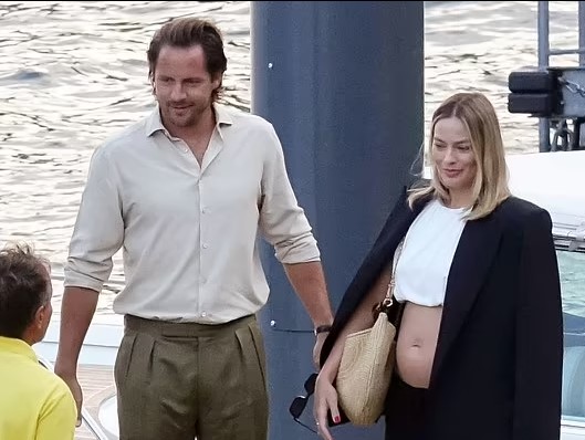 Pregnant Margot Robbie, 34, shows off midriff in white